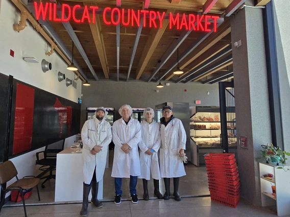 Meat Workers Stand in Front of the Wildcat Country Market